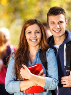 Two happy students in front of the campus