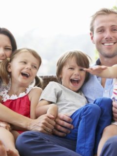 Family Sitting  On Garden Seat Together