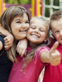18184841 - happy children showing ok sign on playground