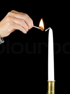 11639094-a-hand-with-a-burning-match-is-lighting-a-white-candle