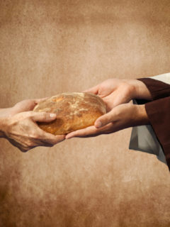 Jesus gives the bread to a beggar.